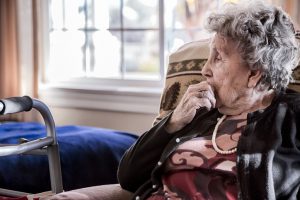 Portrait of an elderly woman sitting alone in a senior care facility