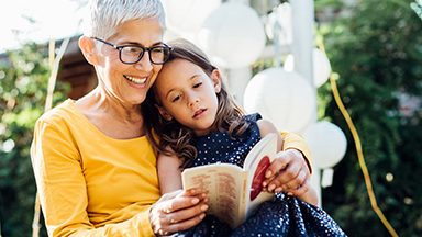 Grandmother reading to young granddaughter