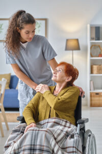 A home health aide comforting a patient in a wheelchair
