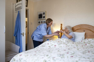 Nurse helping patient sitting in bed. 
