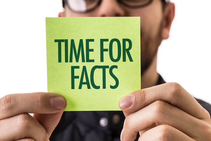 man holding note that states "time for facts"